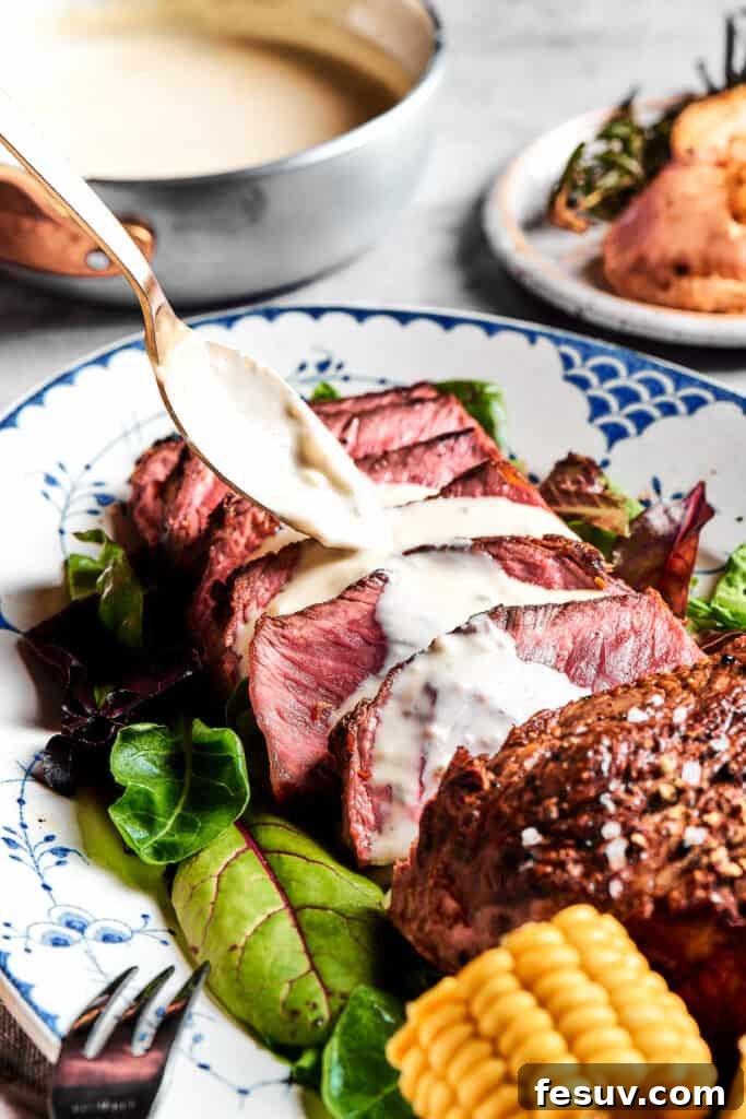 A pristine white platter featuring expertly sliced blue steak, with a luscious blue cheese sauce being artfully spooned over each tender piece, ready to be served.