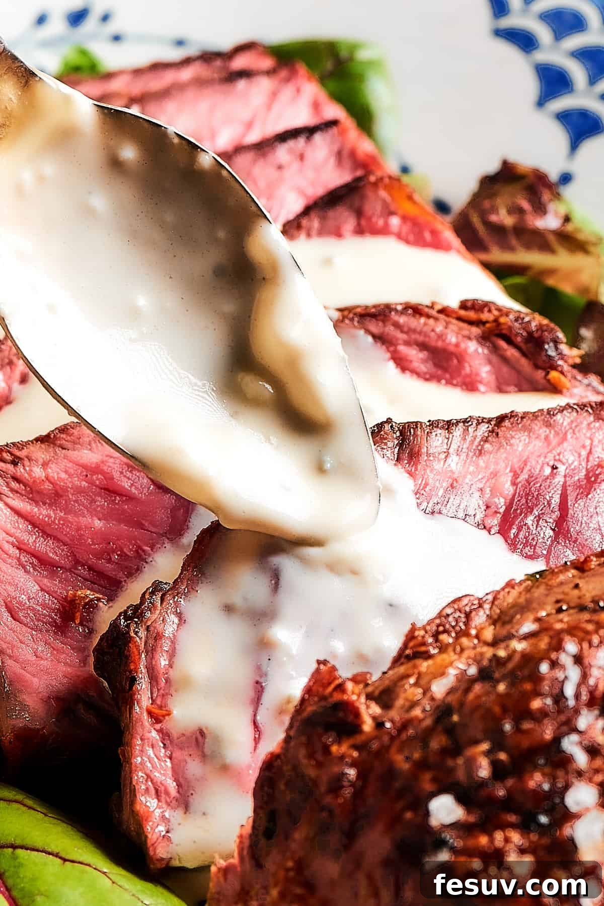 A pristine white platter showcasing meticulously sliced blue steak, each piece perfectly displaying its ultra-rare interior, artfully drizzled with a rich blue cheese sauce.