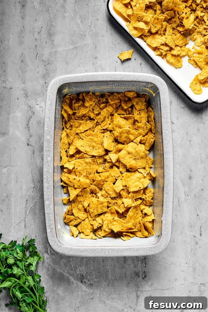 Fiesta Chicken Casserole 5 A baking dish with a base layer of crushed corn chips.