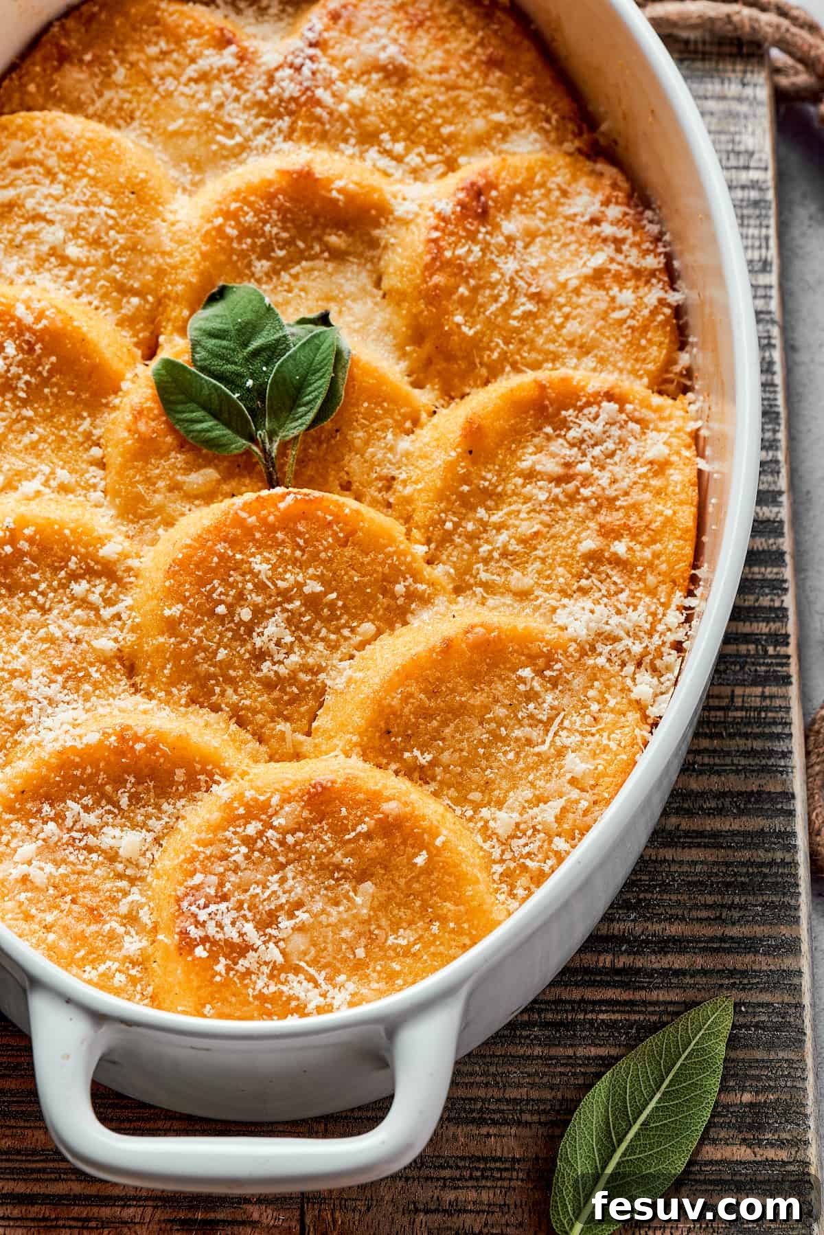An oval baking dish holding about 13 round gnocchi, perfectly baked with crispy Parmesan topping.