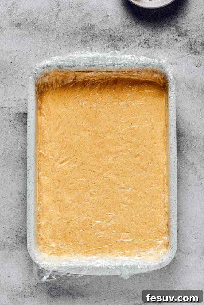 A baking dish with a smooth layer of gnocchi dough inside, ready for shaping.