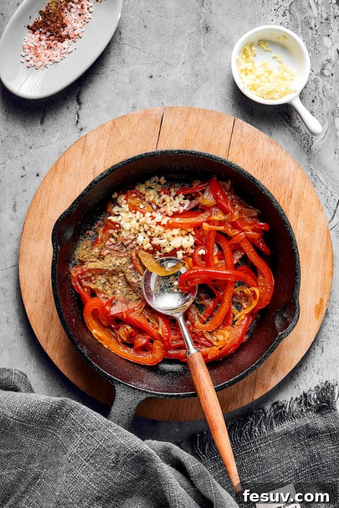 The Ultimate Shakshuka 7 Bell peppers, seasonings, and garlic in a skillet.