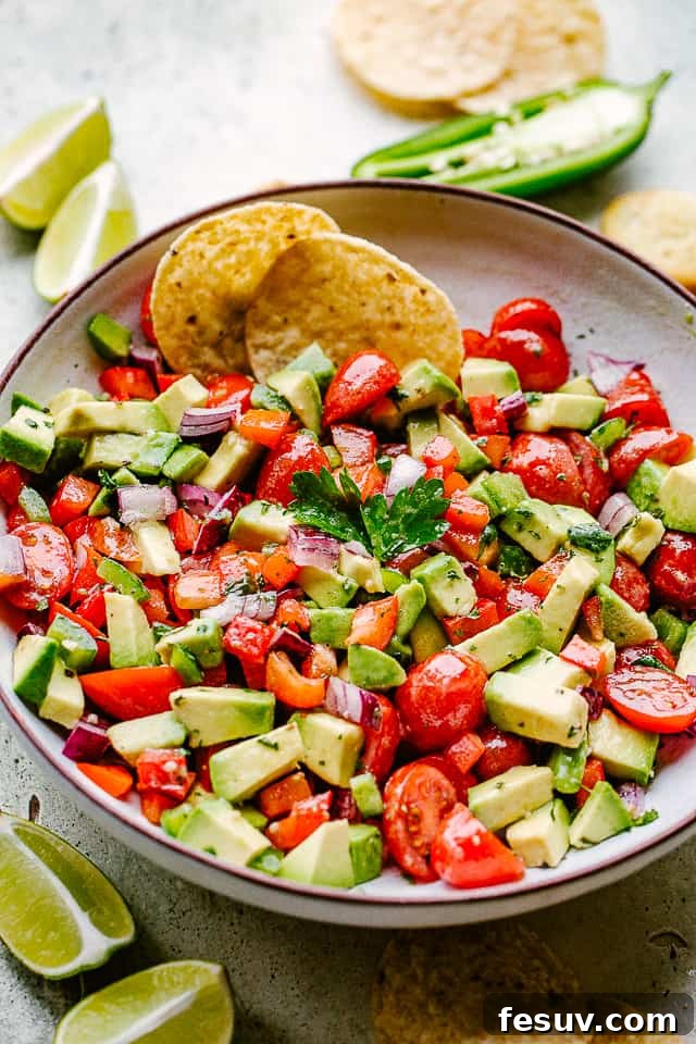 Creamy and Chunky Avocado Salsa with Tortilla Chips for the Perfect Dip Avocado salsa served in a vibrant bowl with warm tortilla chips and lime wedges on the side.