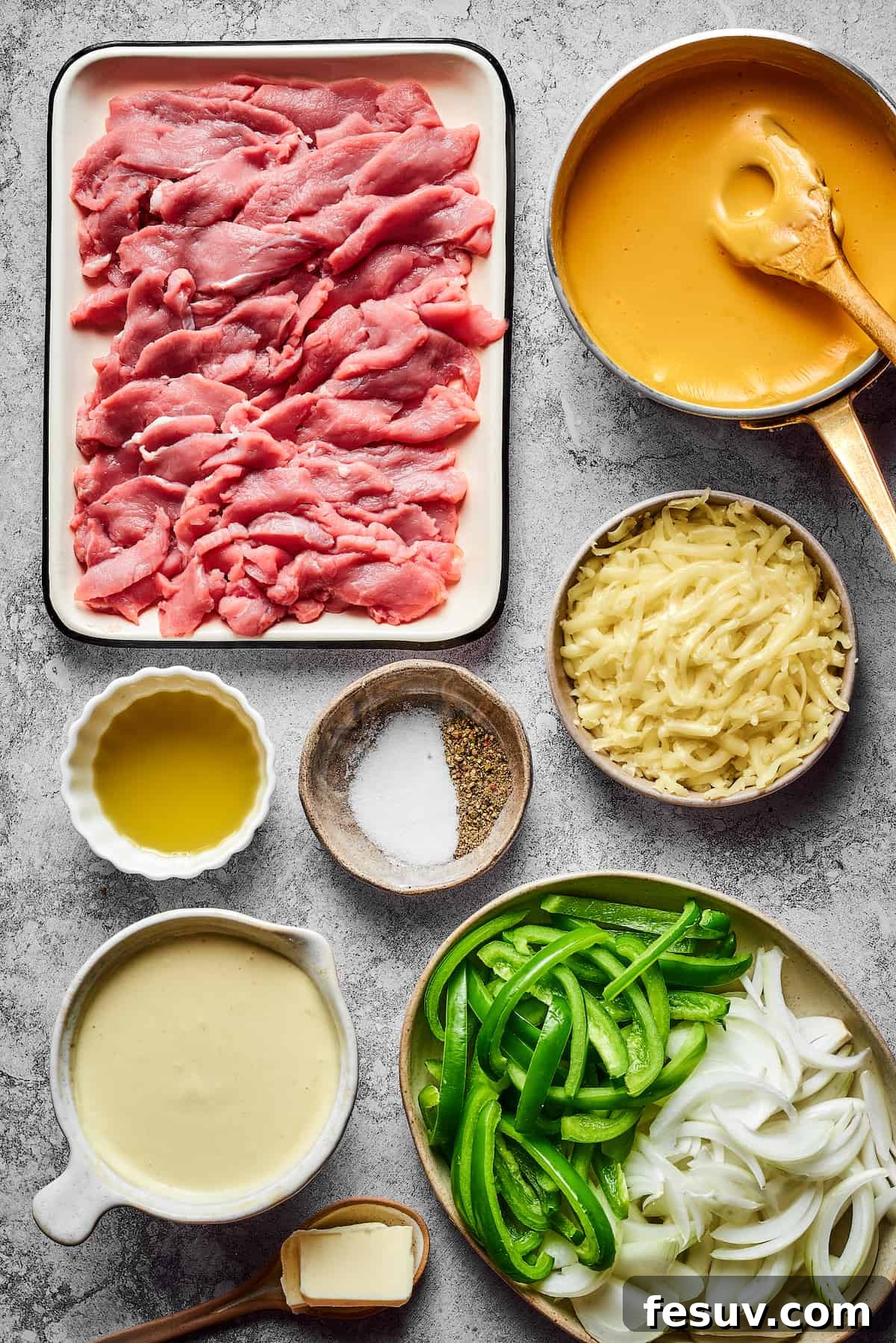 From top left: Thinly sliced steak, cheez whiz, olive oil, salt and pepper, grated provolone, aioli, onions, green bell peppers, butter.