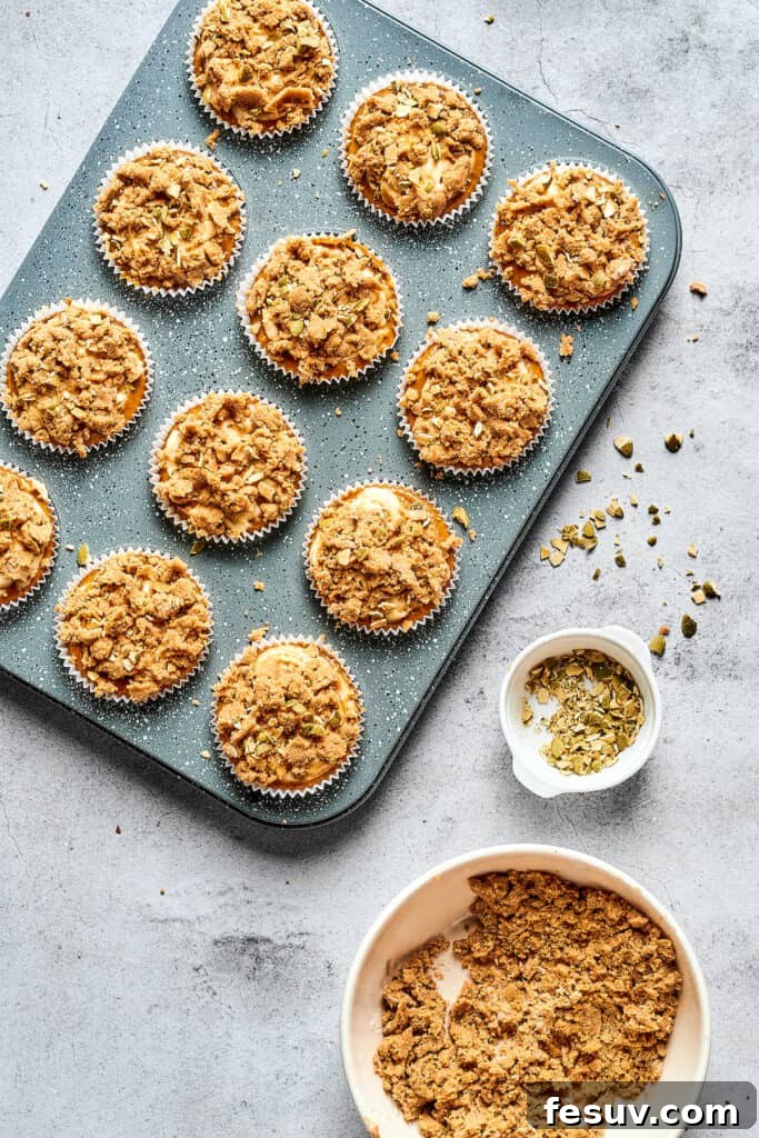 Cream Cheese Swirl Pumpkin Muffins 7 Muffins in a tin, topped with crumbly streusel.