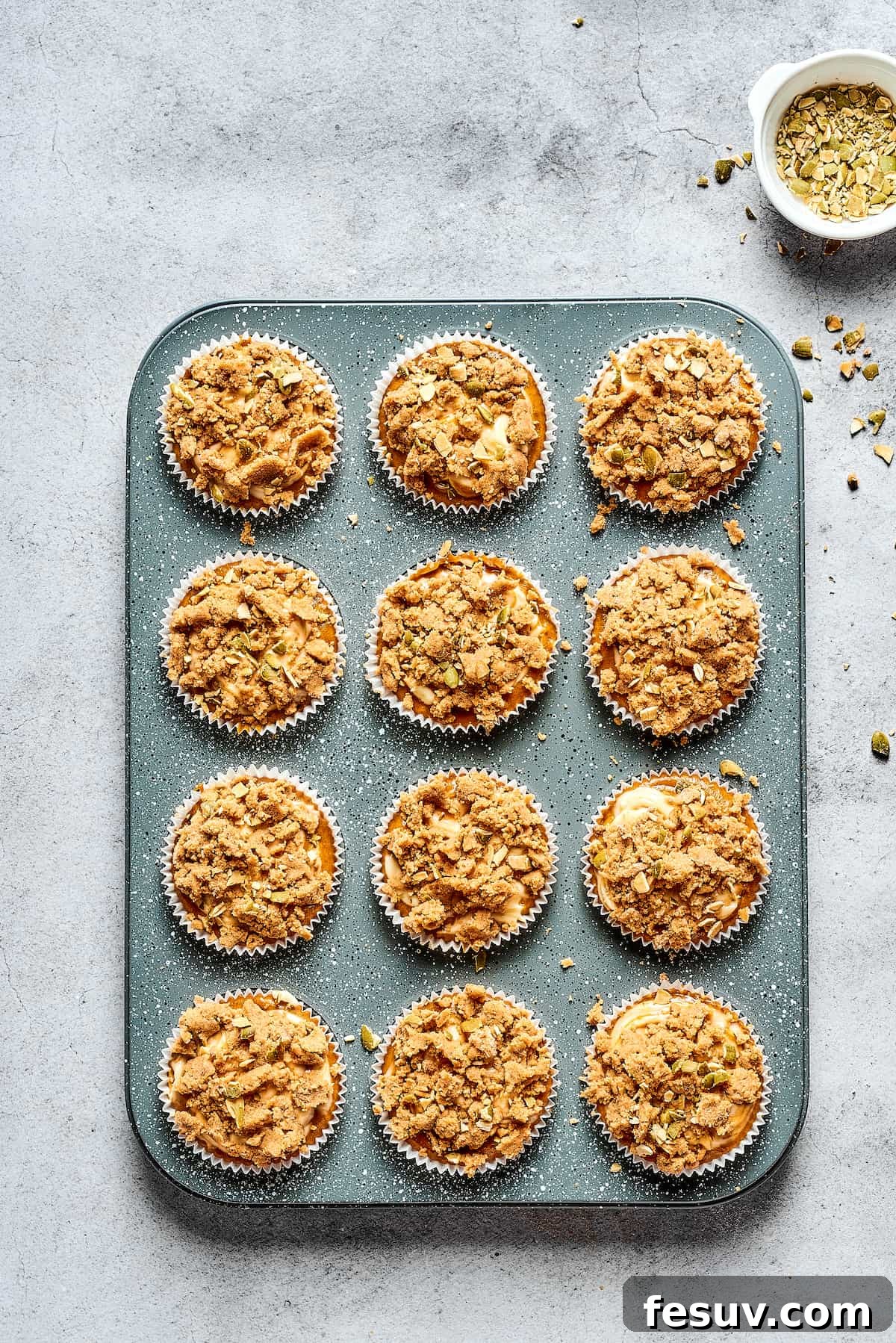 Pumpkin Cream Cheese Muffins are a heavenly mix of spiced pumpkin cake and smooth cream cheese swirl, with a buttery, streusel-like topping. Pumpkin cream cheese muffins in a tin.