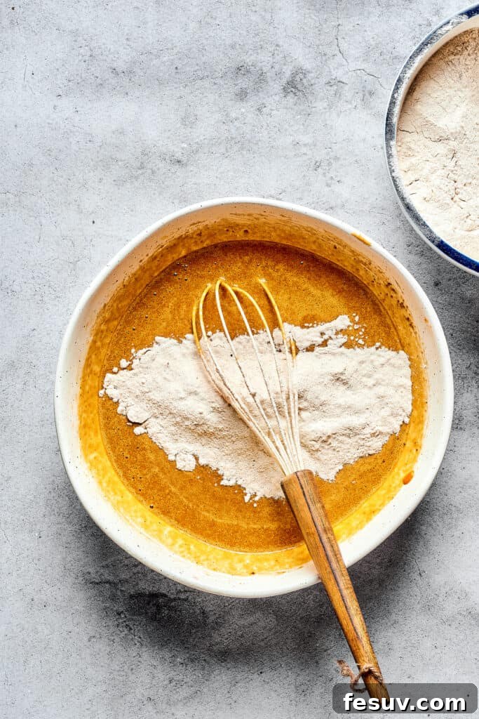 Cream Cheese Swirl Pumpkin Muffins 3 A bowl of pumpkin batter with dry ingredients and a whisk.