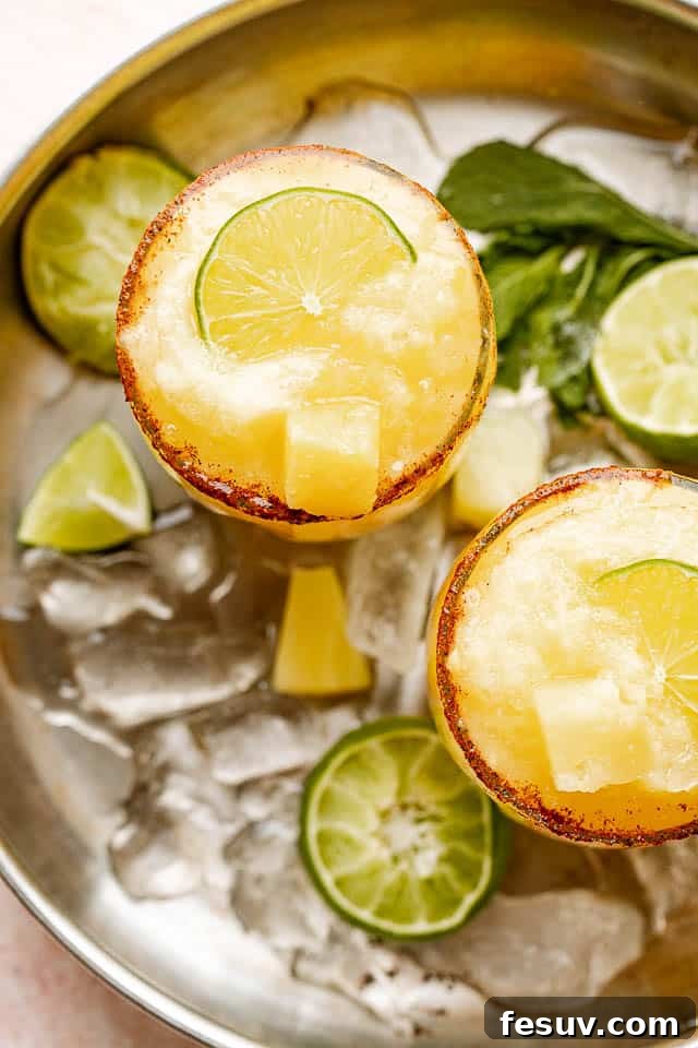 top view of frozen margaritas garnished with limes and pineapples