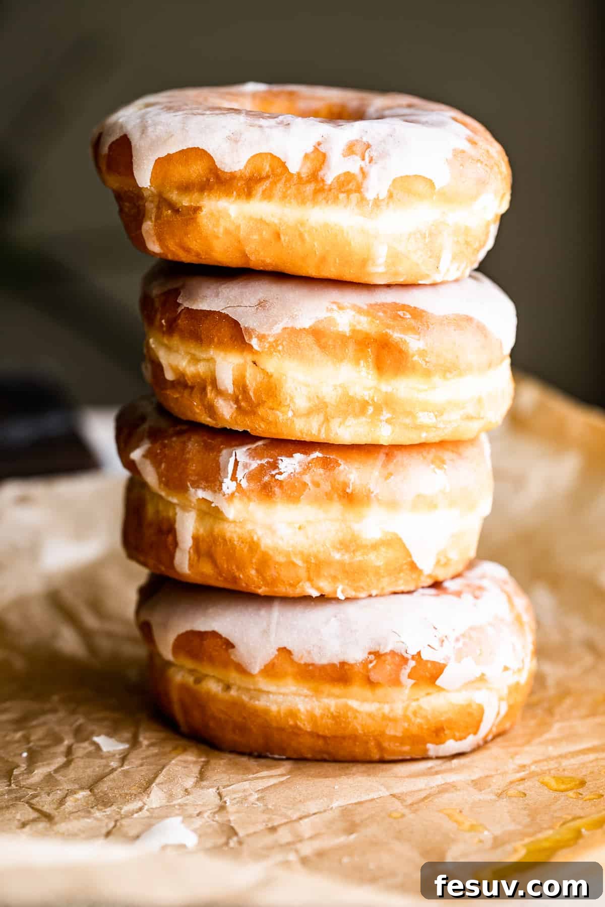 A stack of four warm apple cider doughnuts, perfectly baked and ready for a fall gathering.