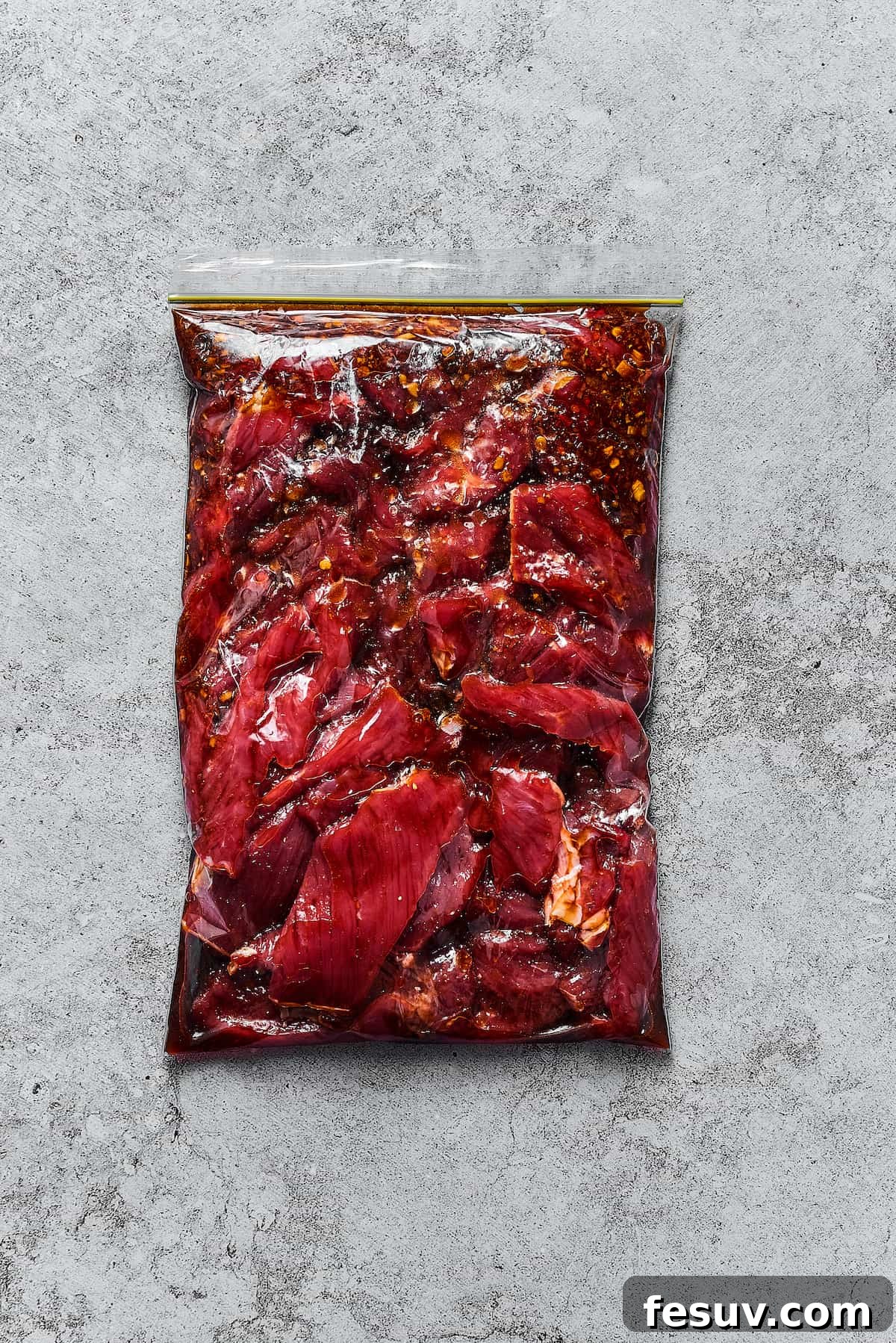 Steak and marinade in a zip-top bag.
