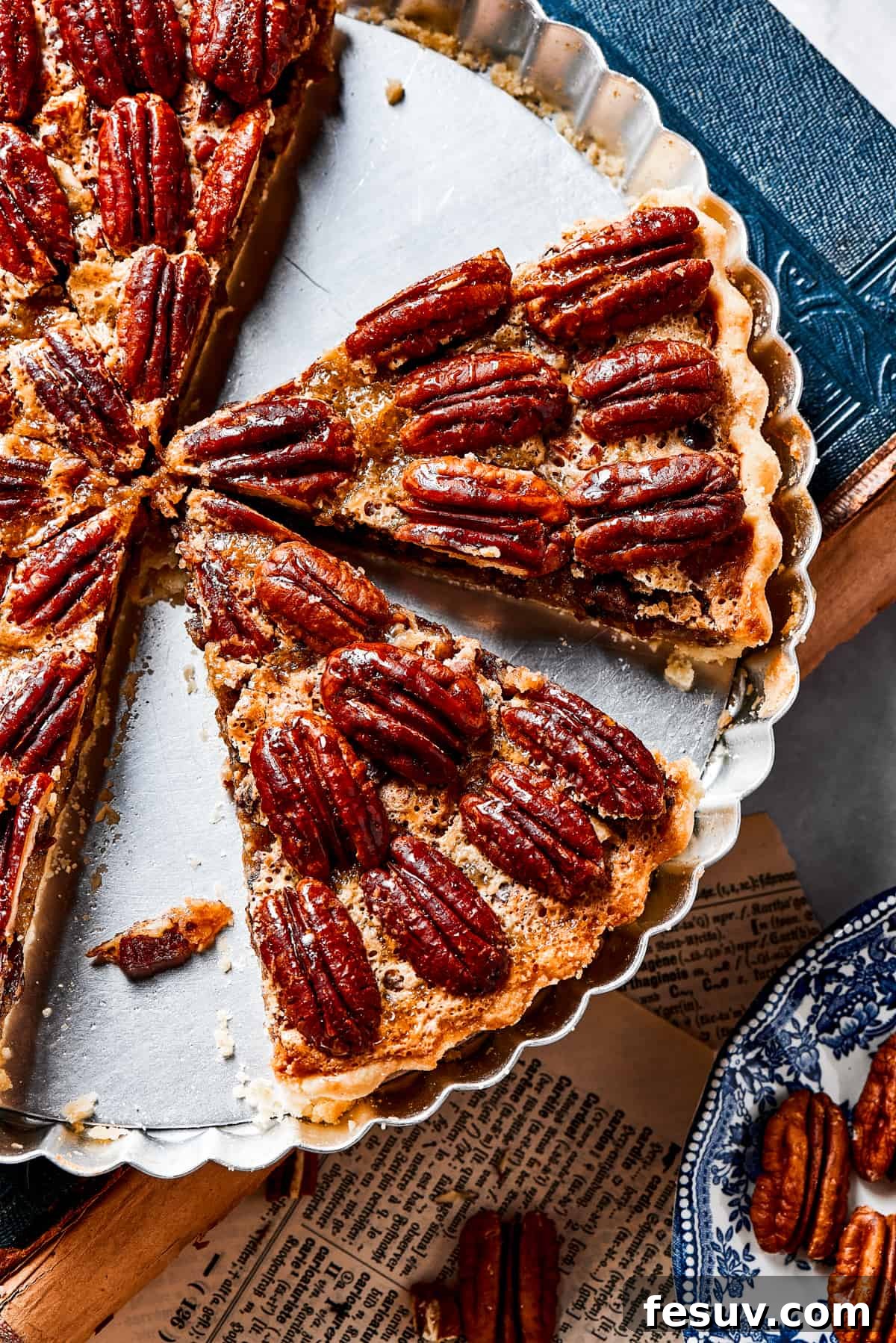 The Best Pecan Pie Recipe is here, easy to make and perfect for your holiday table! You'll love the homemade crust and sweet, nutty filling. A pie dish with several slices of pecan pie left in it.