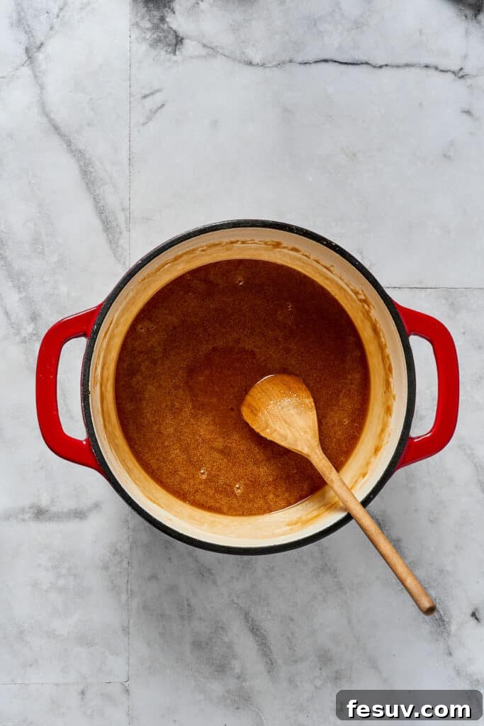 Decadent Pecan Pie Perfection 3 A sugar-syrup mixture in a saucepan.