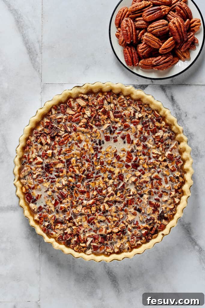 Decadent Pecan Pie Perfection 5 Overhead shot of a partially-assembled pecan pie. The pecan halves have not yet been added.