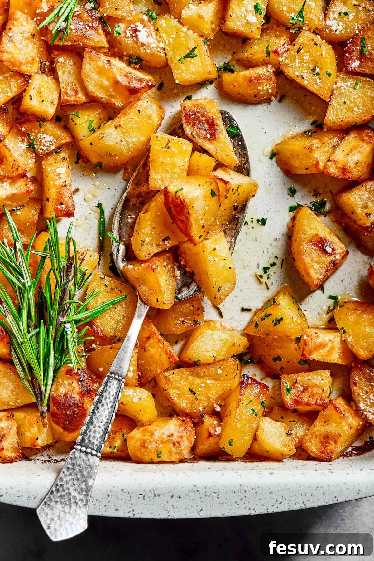 ed Potatoes are crisp, buttery, and easy to make. With a simple seasoning of salt, pepper, and rosemary, they're irresistible! Overhead shot of seasoned baked potato chunks in a baking dish.