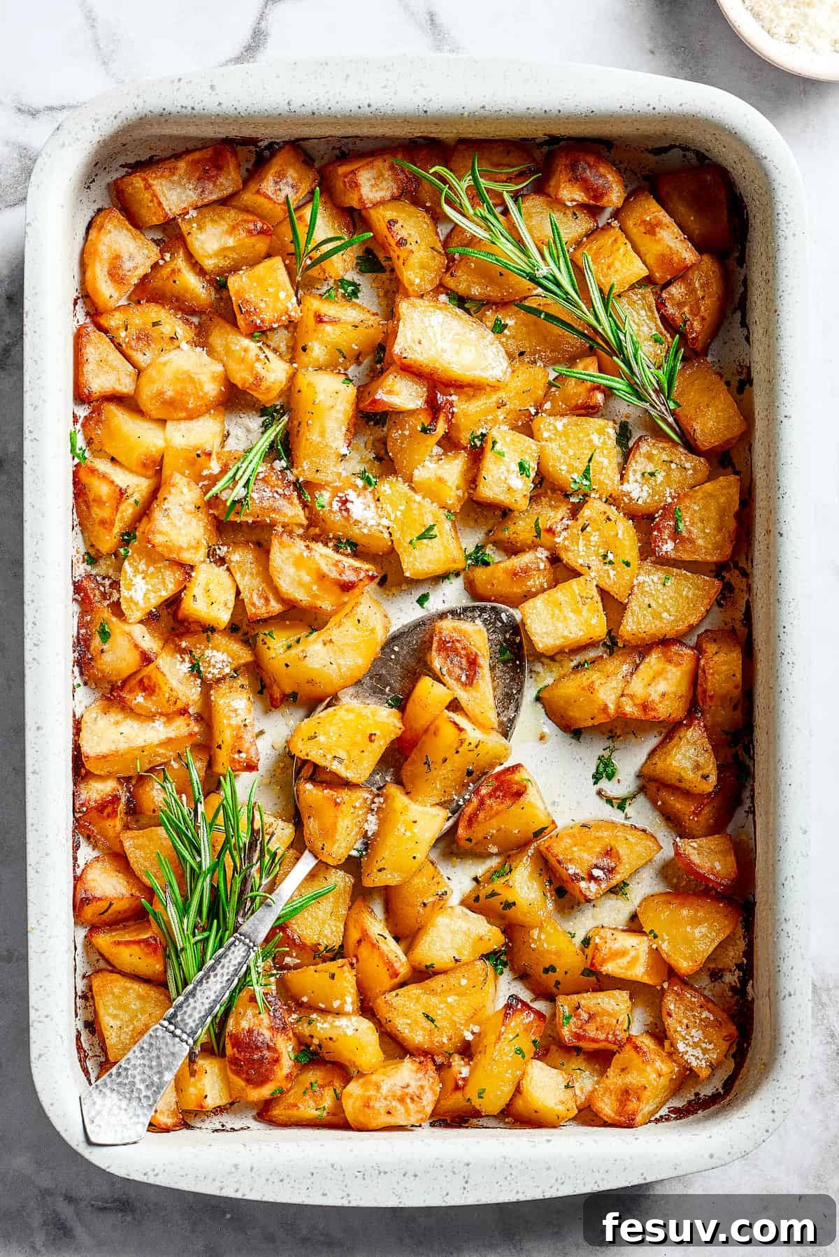 ed Potatoes are crisp, buttery, and easy to make. With a simple seasoning of salt, pepper, and rosemary, they're irresistible! A large baking dish full of baked, seasoned potato pieces.