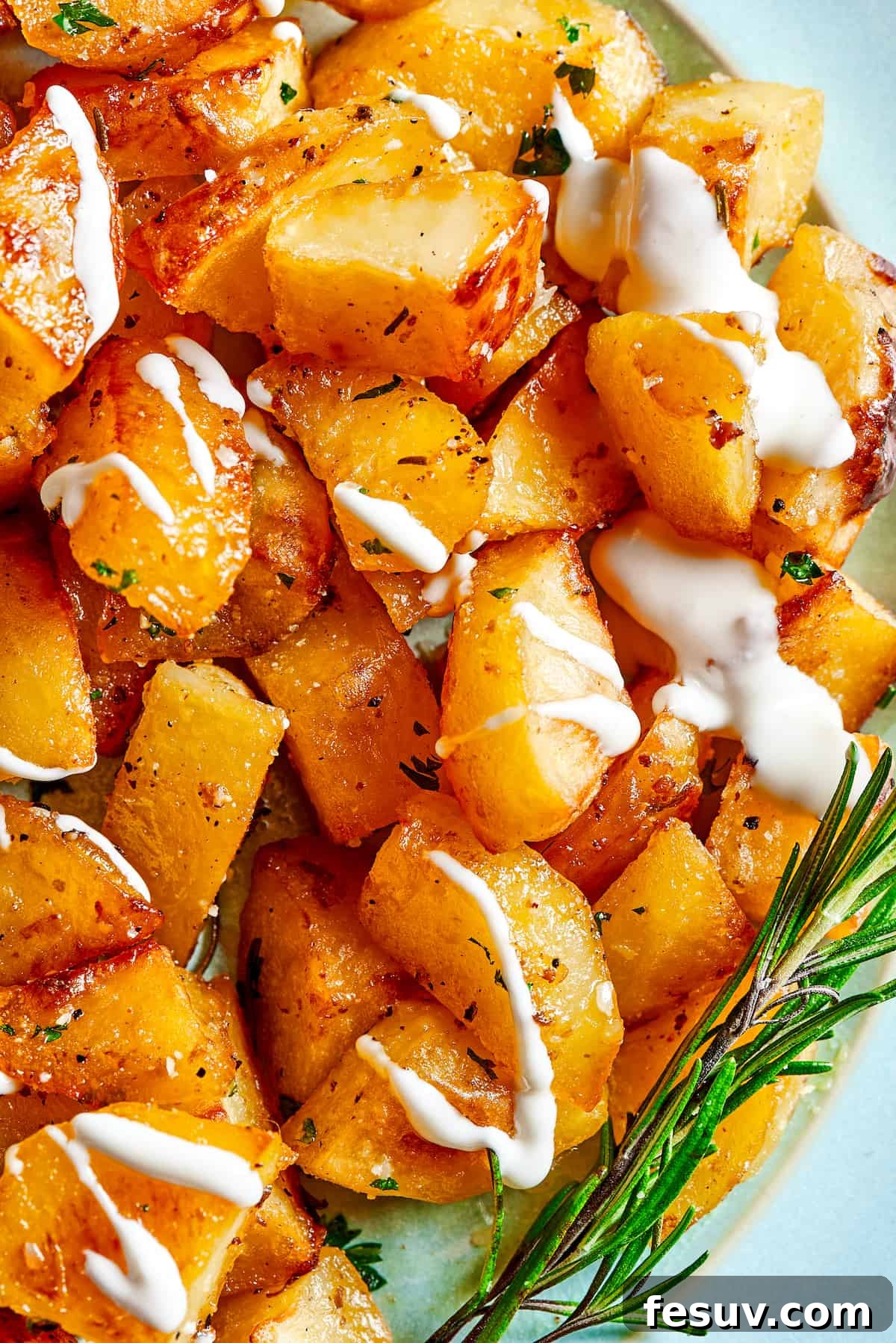 ed Potatoes are crisp, buttery, and easy to make. With a simple seasoning of salt, pepper, and rosemary, they're irresistible! Close up shot of roast seasoned potatoes garnished with rosemary and yogurt.