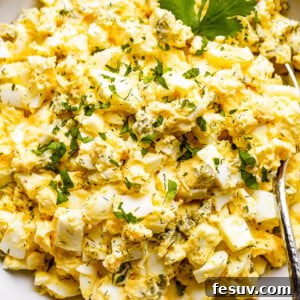 scooping out egg salad from a bowl