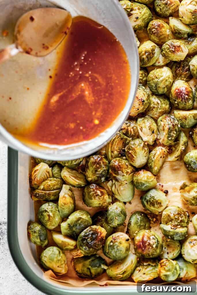 Crispy Brussels Perfection 6 Adding the sweet and tangy maple-pomegranate glaze to a baking sheet of roasted Brussels sprouts.