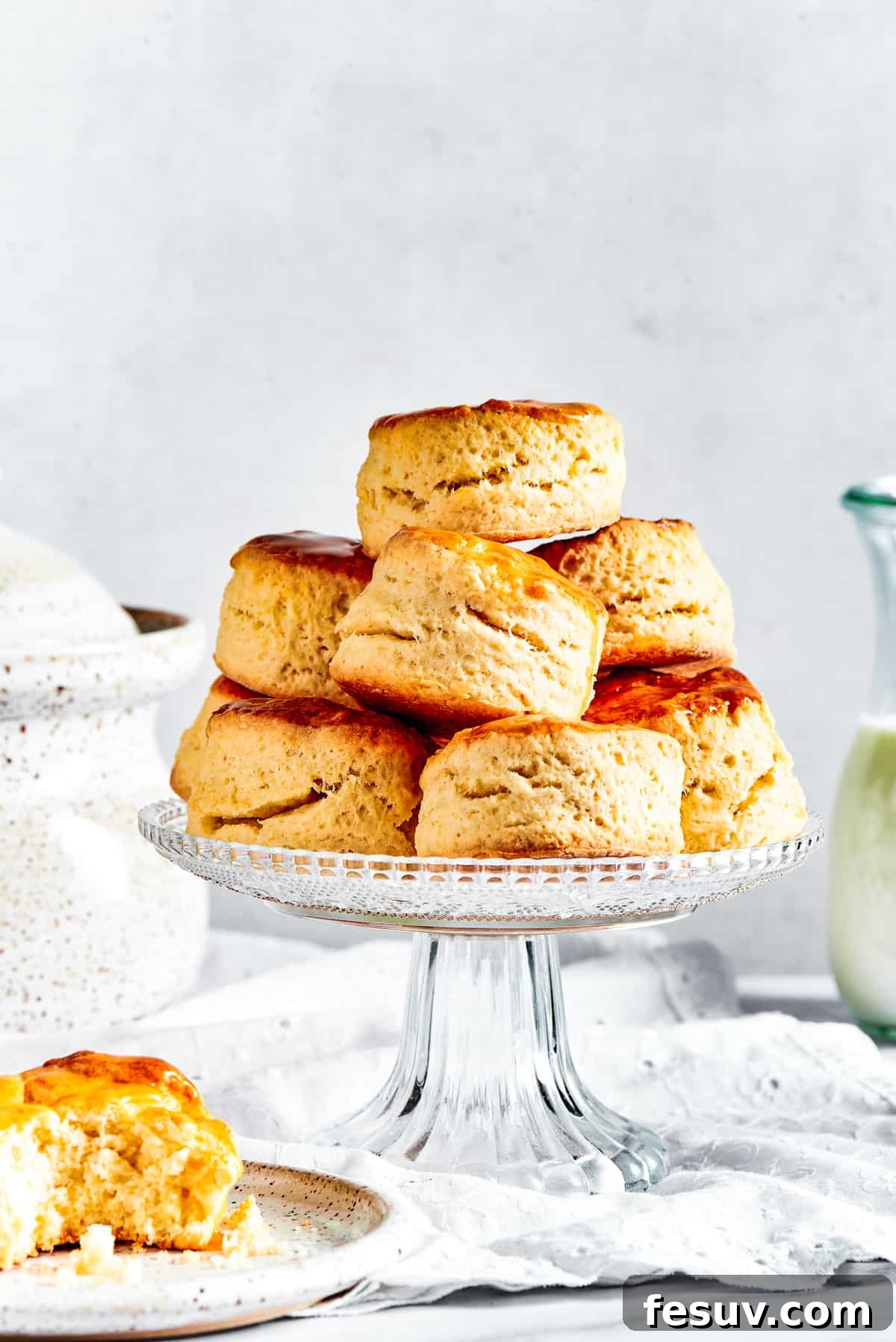 Easy Homemade Biscuits are a buttery, flaky must-have for special meals, and they are so simple to make! Fluffy, melt-in-your-mouth biscuits. Freshly baked homemade biscuits displayed on a tiered cake stand, with one perfectly round biscuit resting on a small saucer beside it, ready to be enjoyed.