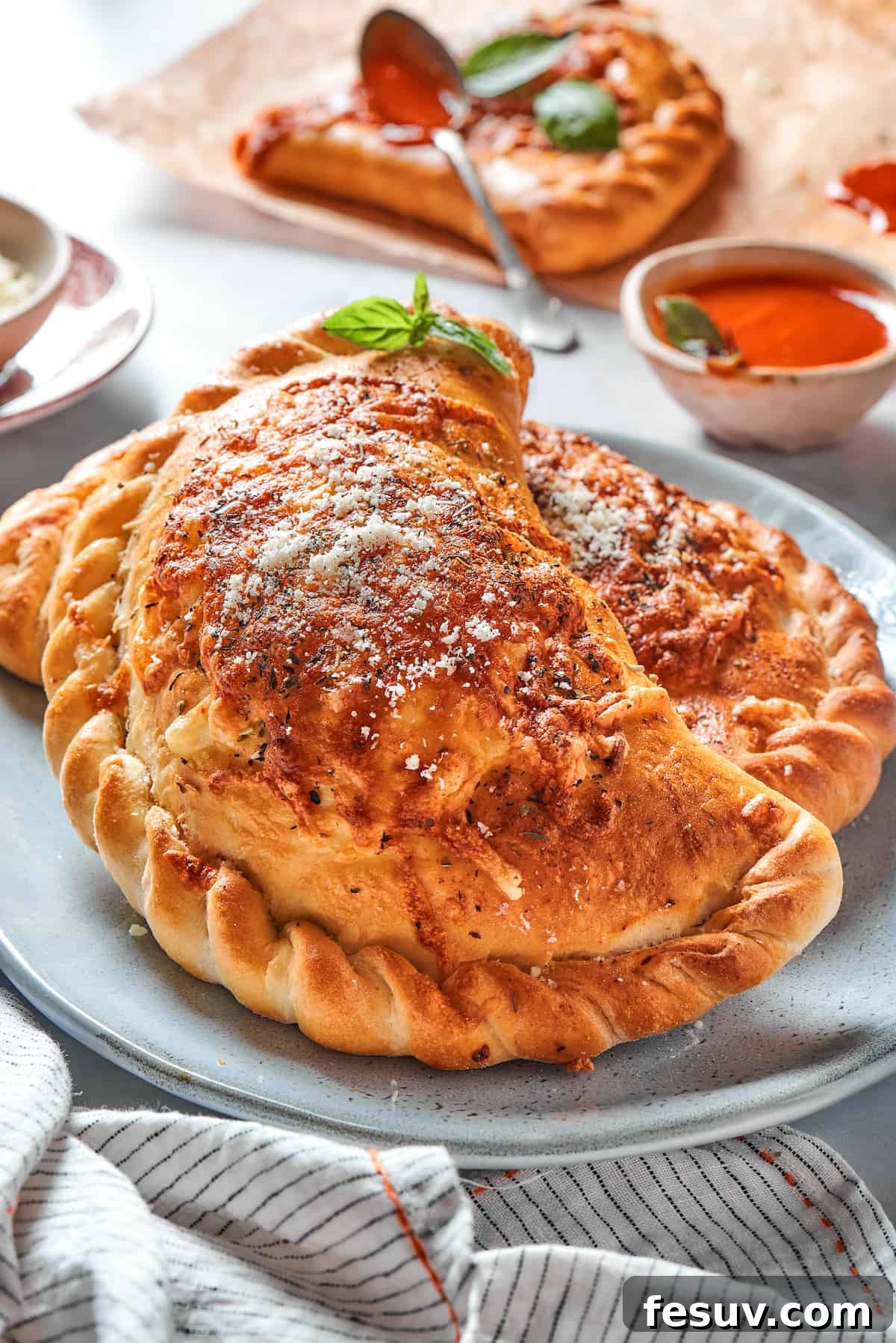Two freshly baked pizza pockets with perfectly crimped edges resting on a plate, ready to be enjoyed.