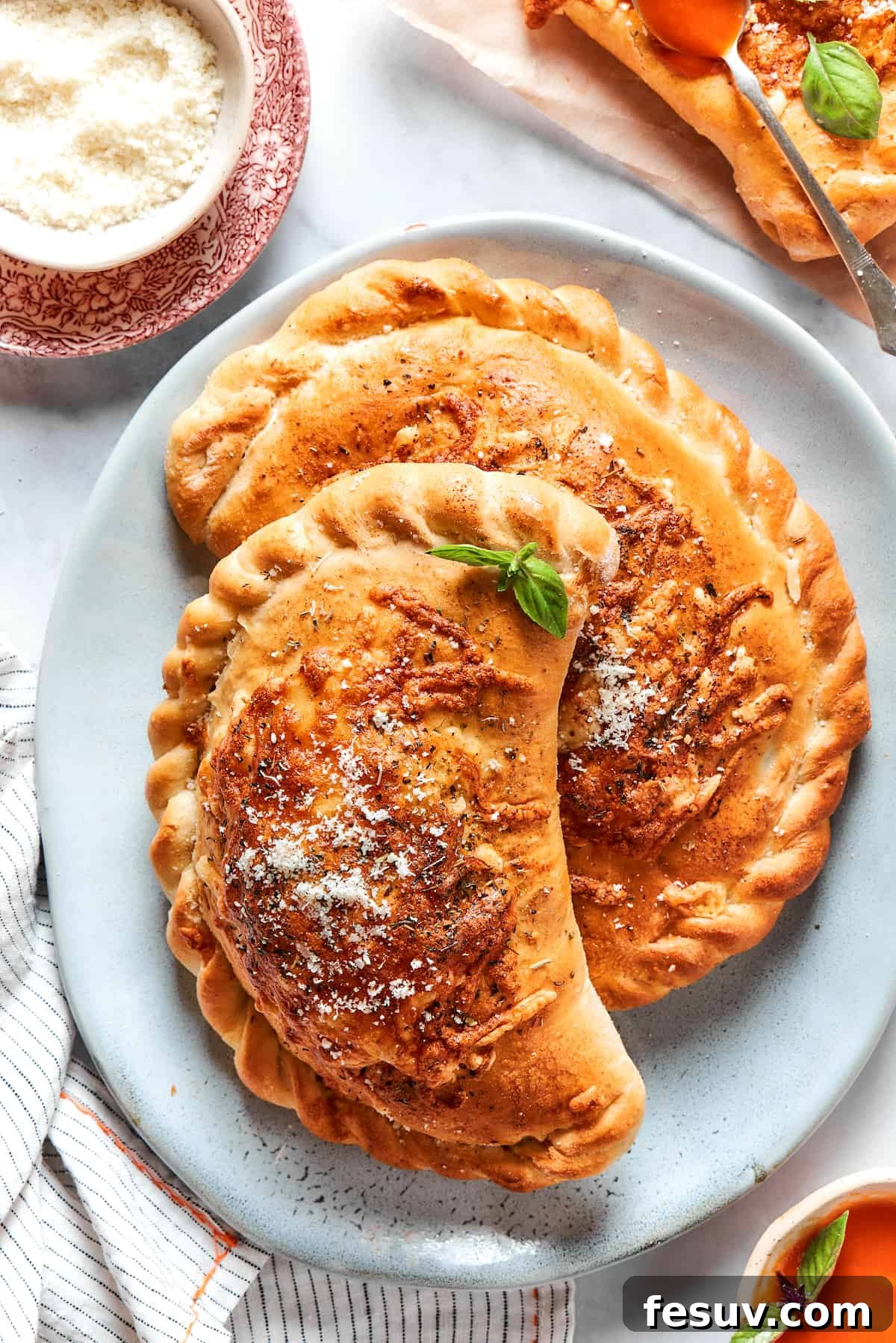 Two freshly baked, golden pizza pockets arranged appealingly on a blue plate, ready to be served.