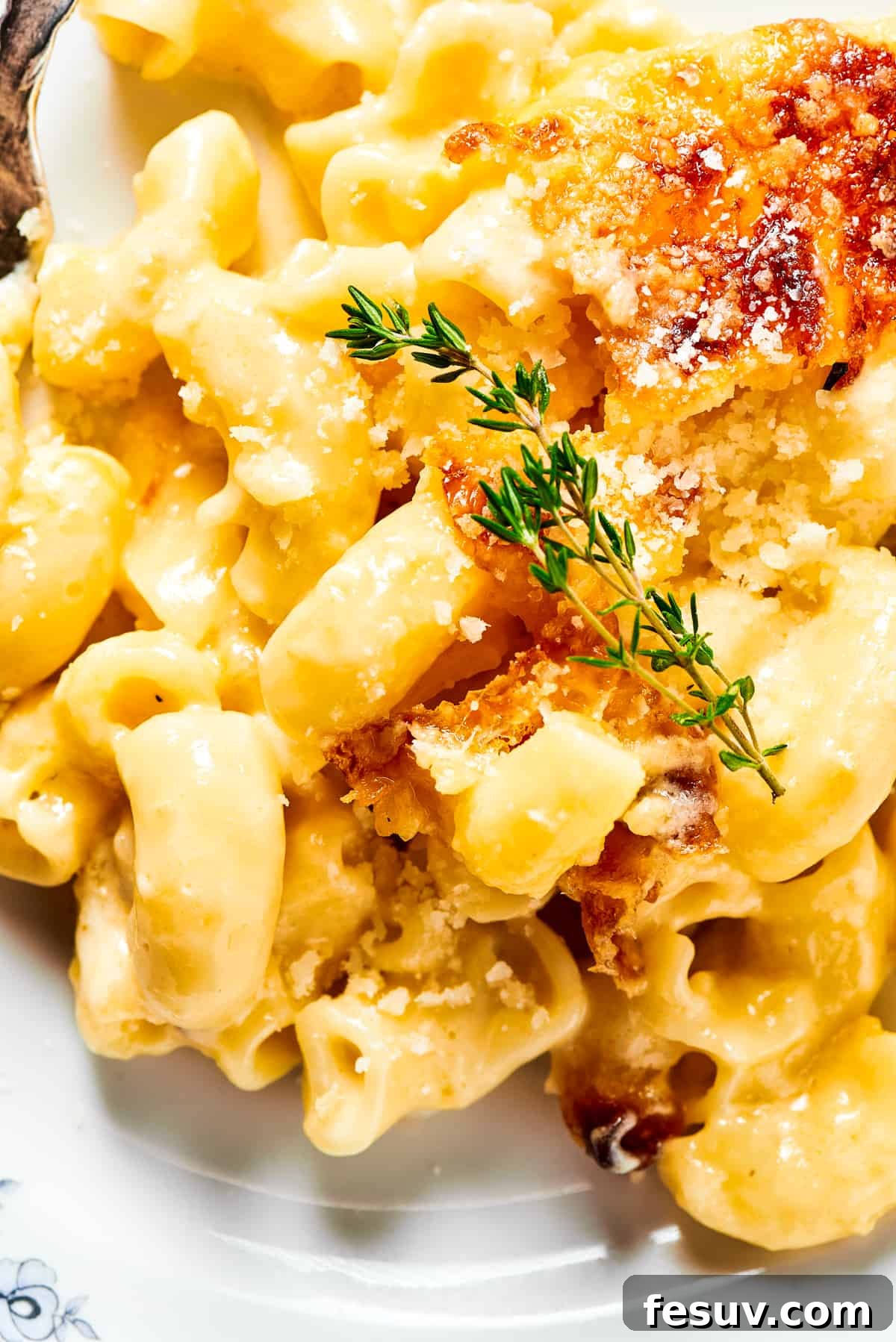 A major family favorite, this ultra-cheesy Baked Macaroni and Cheese is easy to make and perfect for holidays, meatless meals, or anytime! A close-up view of the baked mac and cheese, highlighting the incredibly creamy texture of the pasta coated in rich cheese sauce, with a hint of golden crust.