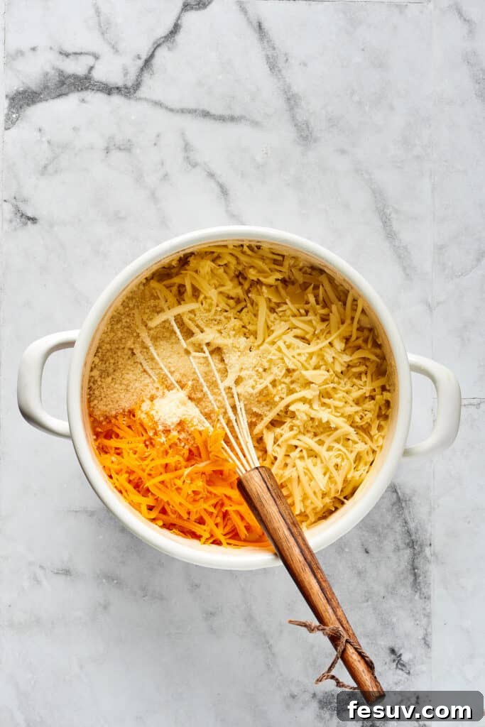 Golden Crusted Macaroni Delight 4 Hands stirring a rich, creamy cheese sauce in a pot, incorporating a mix of shredded cheeses and seasonings.
