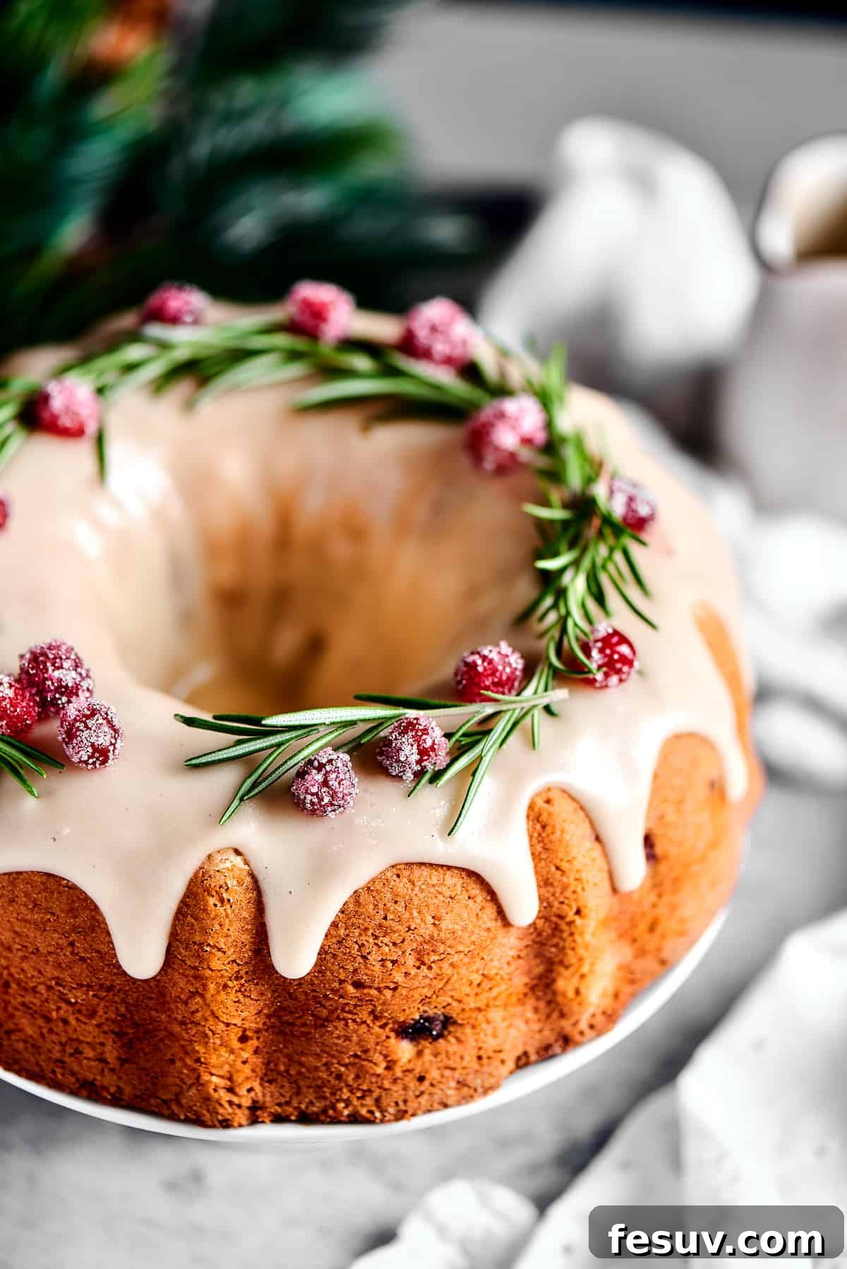 Winterberry Pound Cake Bliss 15 Another beautiful overhead shot of the festive Bundt cake, adorned with glistening sugared cranberries and aromatic rosemary sprigs, emphasizing its holiday appeal.