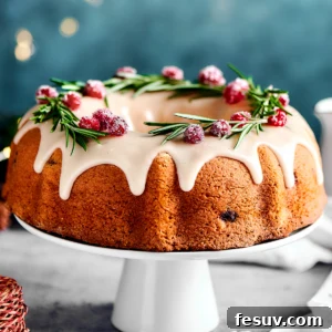 cranberry cake on a white cake stand, with lights in the background of the shot.