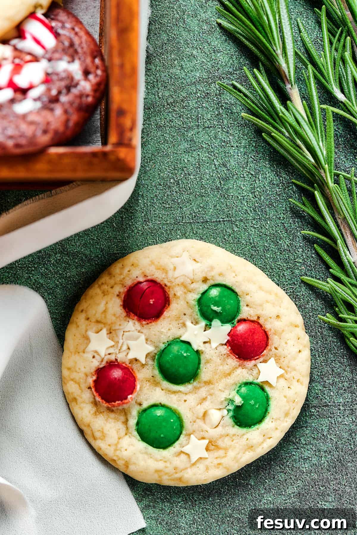 A beautifully decorated Christmas sugar cookie, adorned with elegant white chocolate stars and festive red and green M&M's.