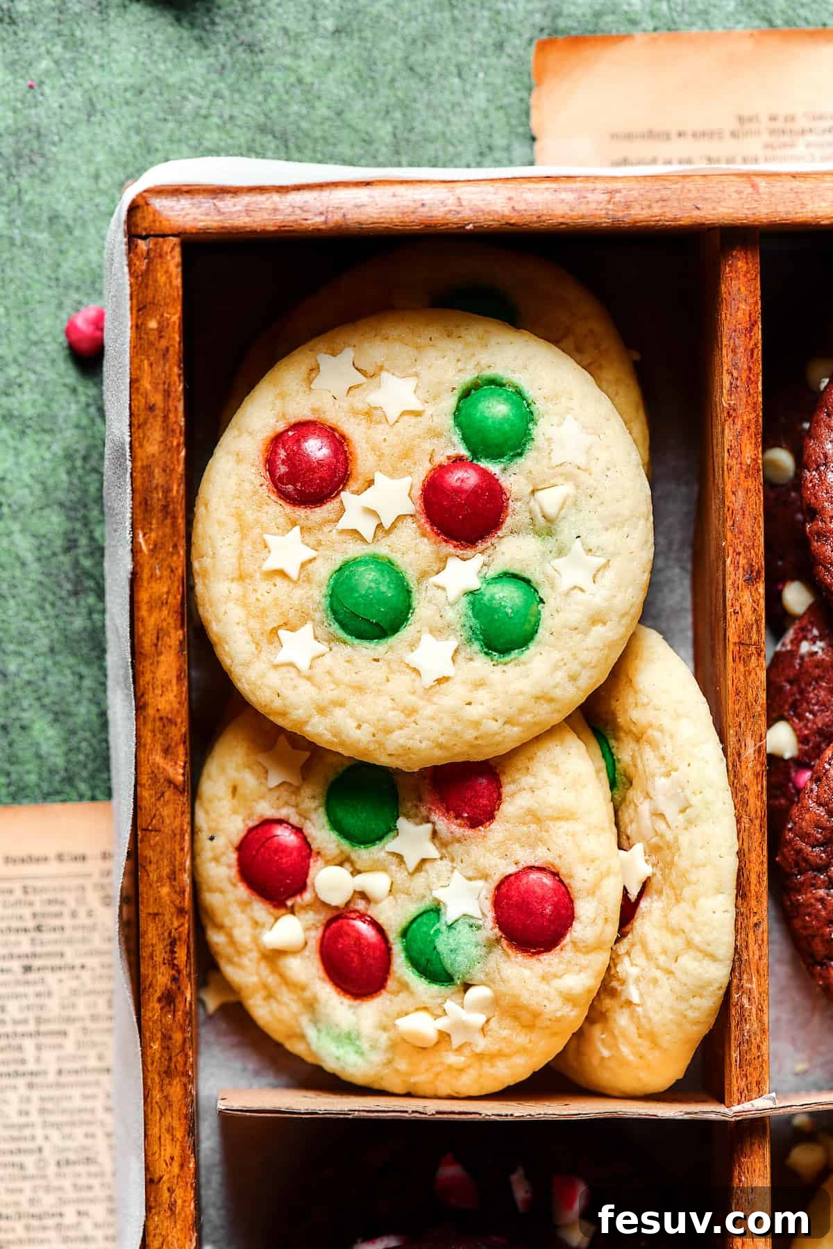 A beautifully decorated Christmas sugar cookie, adorned with festive red and green M&M's and delicate white chocolate stars, ready for the holidays.