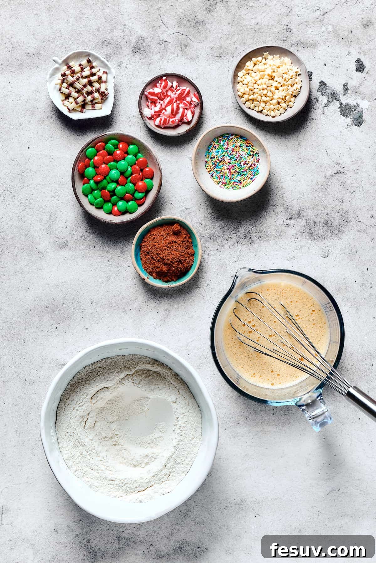 Various cake mix cookie ingredients are meticulously arranged: dry ingredients blended in one bowl, wet ingredients in another, and colorful decorations await in small dishes.