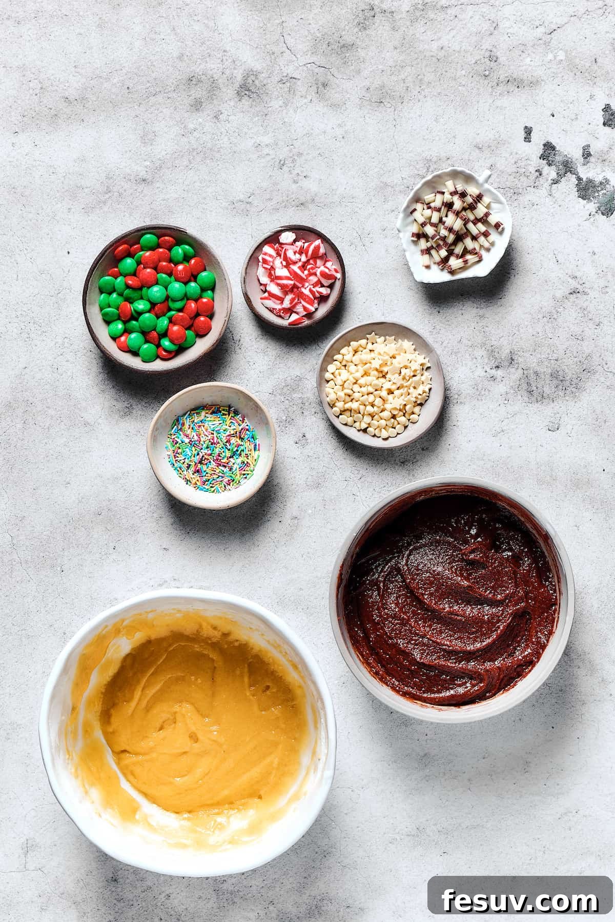 Two enticing bowls of cookie dough, one rich chocolate and one classic vanilla, sit prepared next to an assortment of colorful decorations.