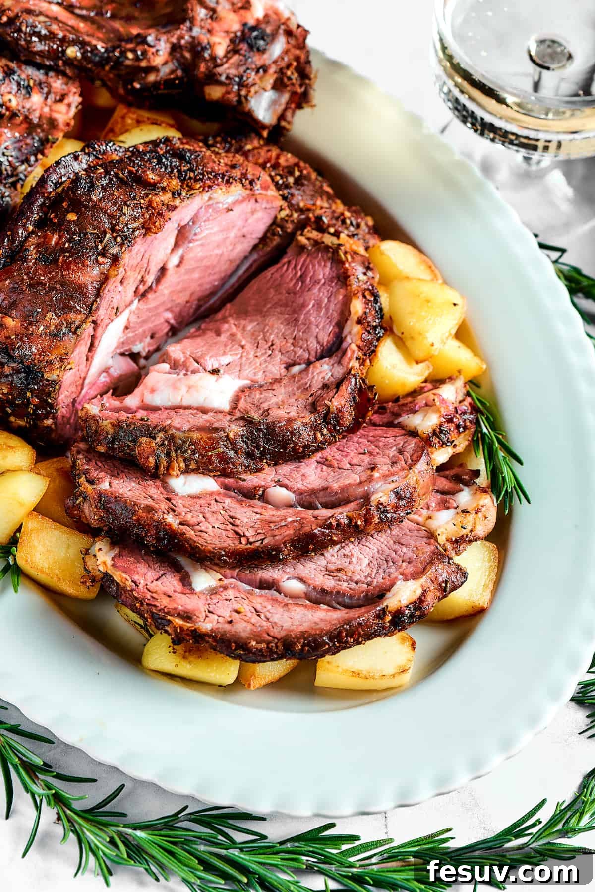 Making the perfect Prime Rib is easy! A few flavorful herbs and spices plus an easy reverse-sear roasting method are all you need. A sliced prime rib roast on a platter.