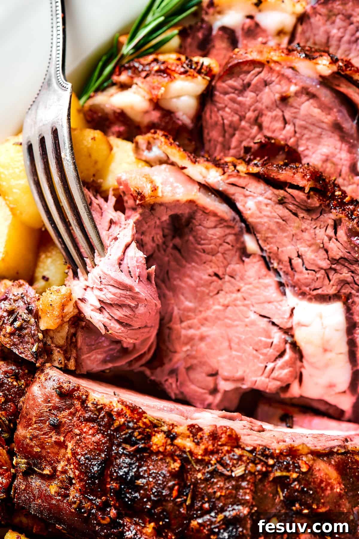 Making the perfect Prime Rib is easy! A few flavorful herbs and spices plus an easy reverse-sear roasting method are all you need. A fork serving a slice of rib roast.
