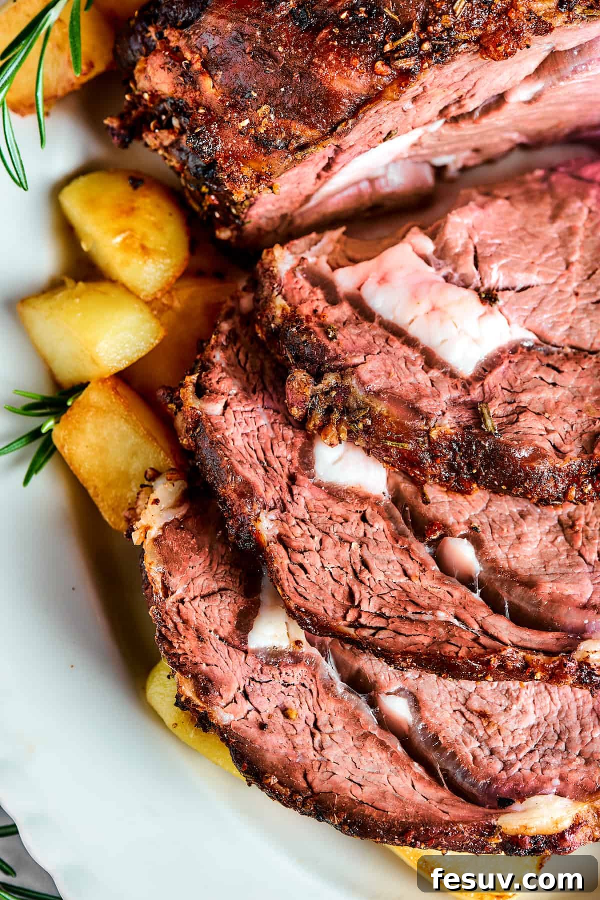 Making the perfect Prime Rib is easy! A few flavorful herbs and spices plus an easy reverse-sear roasting method are all you need. Medium-rare sliced rib roast.