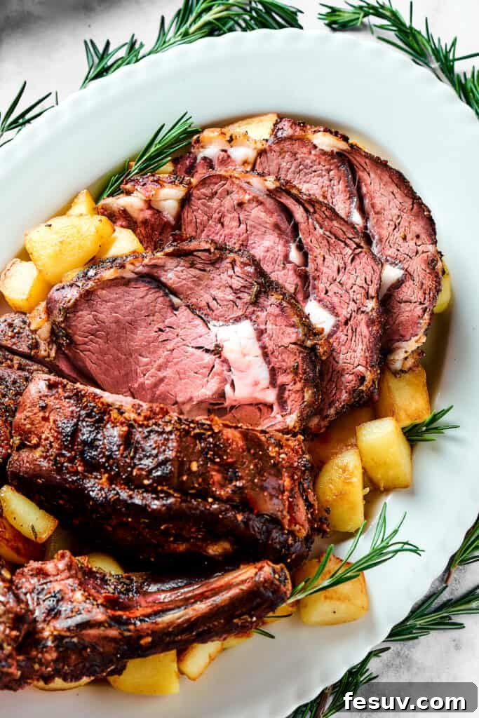 Regal Rib Roast 7 Sliced standing rib roast on a serving patter with potatoes and herbs.