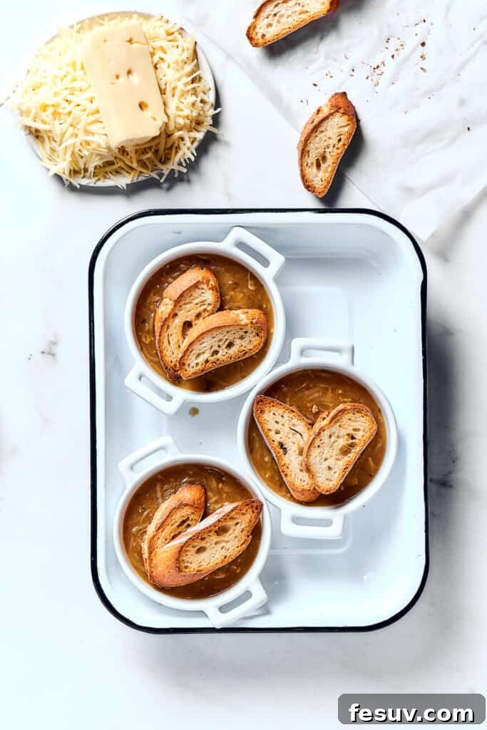 Caramelized Onion Elixir 9 Individual oven-proof bowls of soup topped with perfectly toasted baguette slices, ready for the cheese layer.