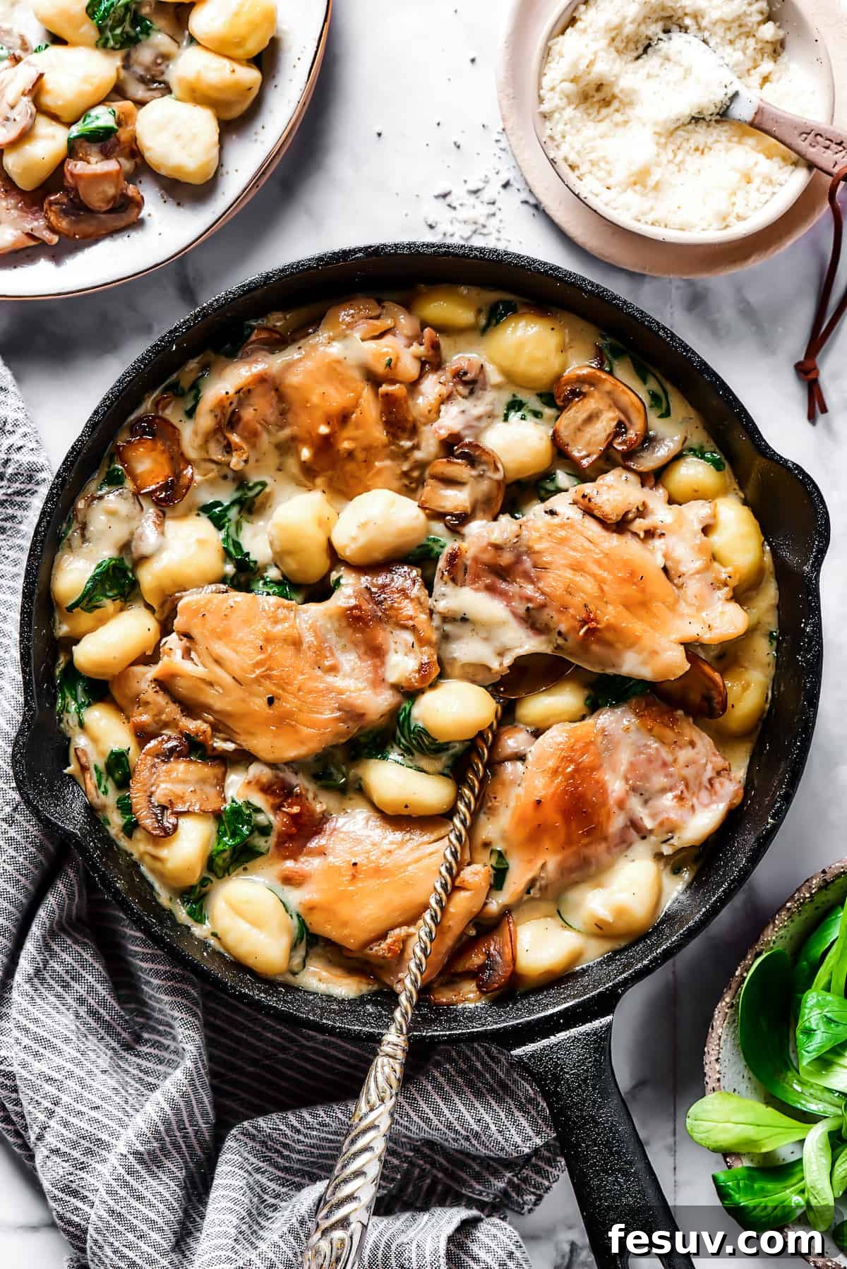 Creamy Chicken & Gnocchi is a bold, yet comforting combo of tender chicken, pillowy gnocchi, and flavorful spinach and mushrooms. Creamy chicken and gnocchi in a cast-iron skillet, ready to be served.