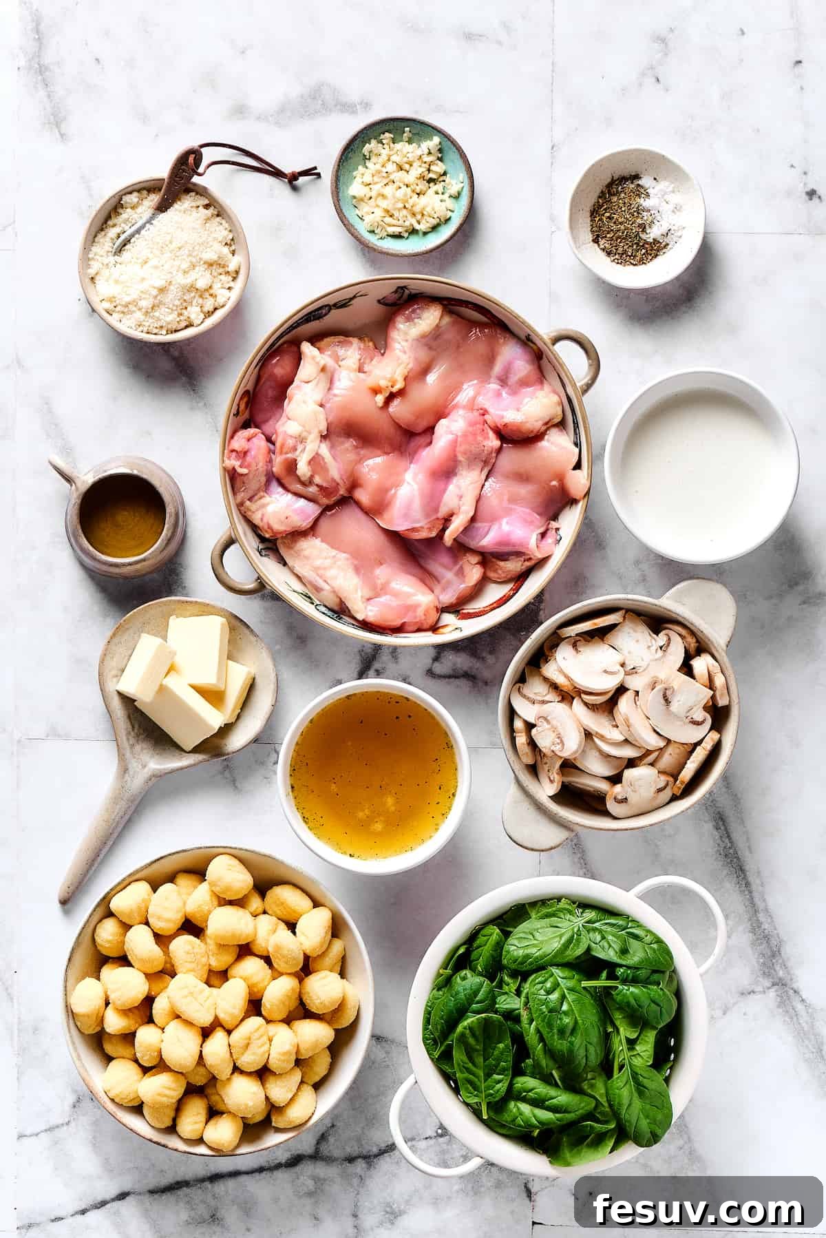 Creamy Chicken & Gnocchi is a bold, yet comforting combo of tender chicken, pillowy gnocchi, and flavorful spinach and mushrooms. Chicken gnocchi ingredients measured and arranged on a table, including chicken, spinach, mushrooms, cream, and gnocchi.