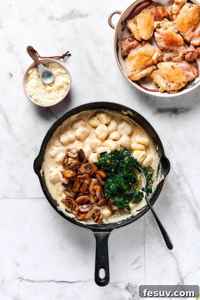 Velvety Chicken Gnocchi Delight 7 Adding cooked mushrooms and spinach back to the skillet with the gnocchi and sauce.