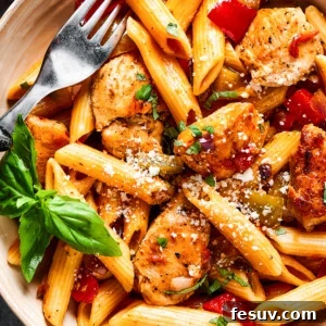 overhead close up of chicken and penne with tomatoes, peppers, and onions.