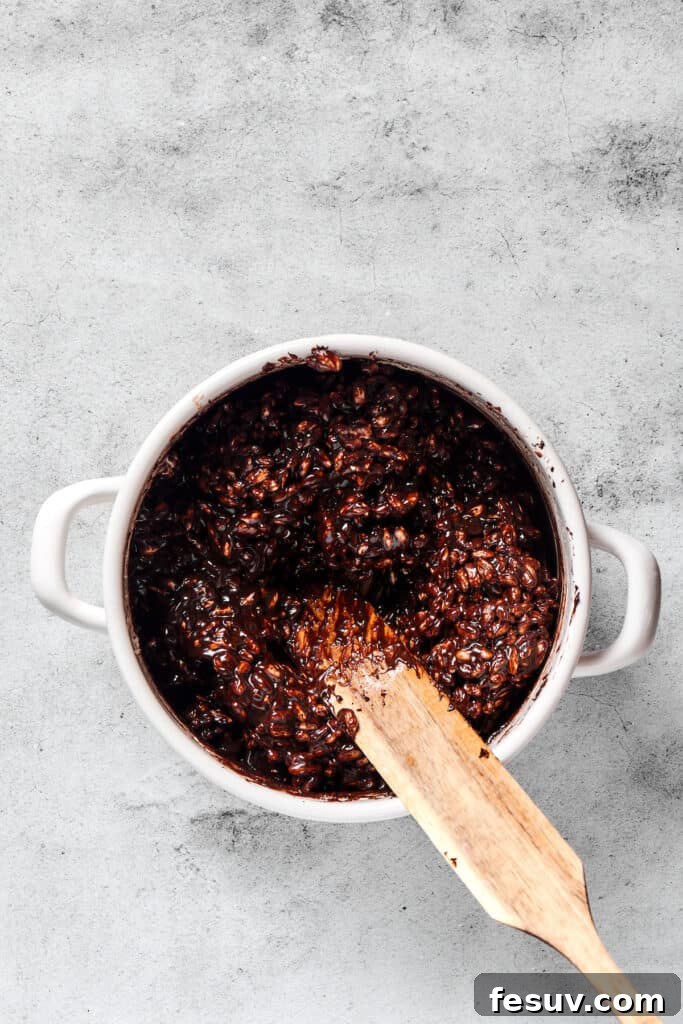 Irresistible Chocolate Krispie Squares 6 Chocolate rice cereal mixture in a pot.