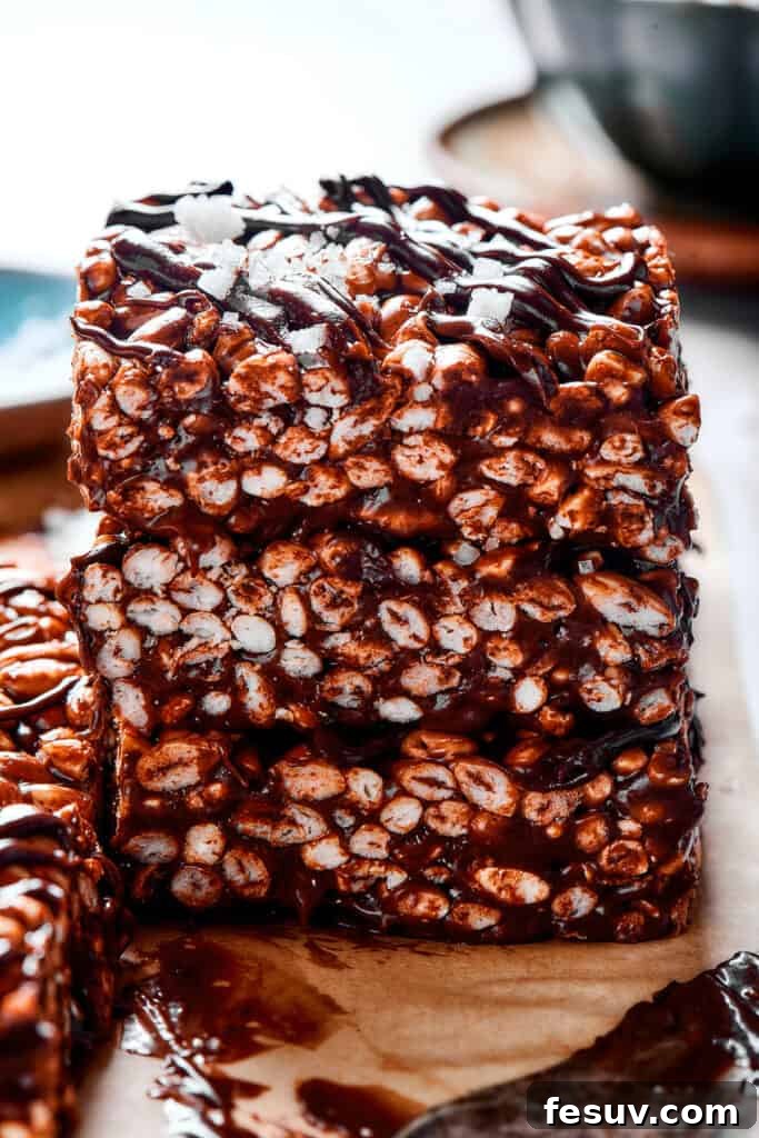 Irresistible Chocolate Krispie Squares 9 Stacked squares of chocolate rice krispie treats with chocolate topping.