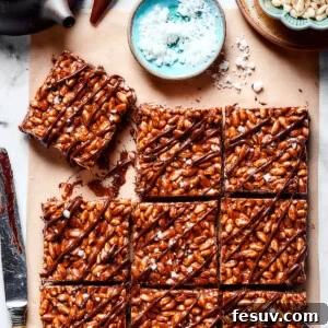 Irresistible Chocolate Krispie Squares 10 Squares of chocolate rice krispie treats next to a bowl of flaky sea salt.