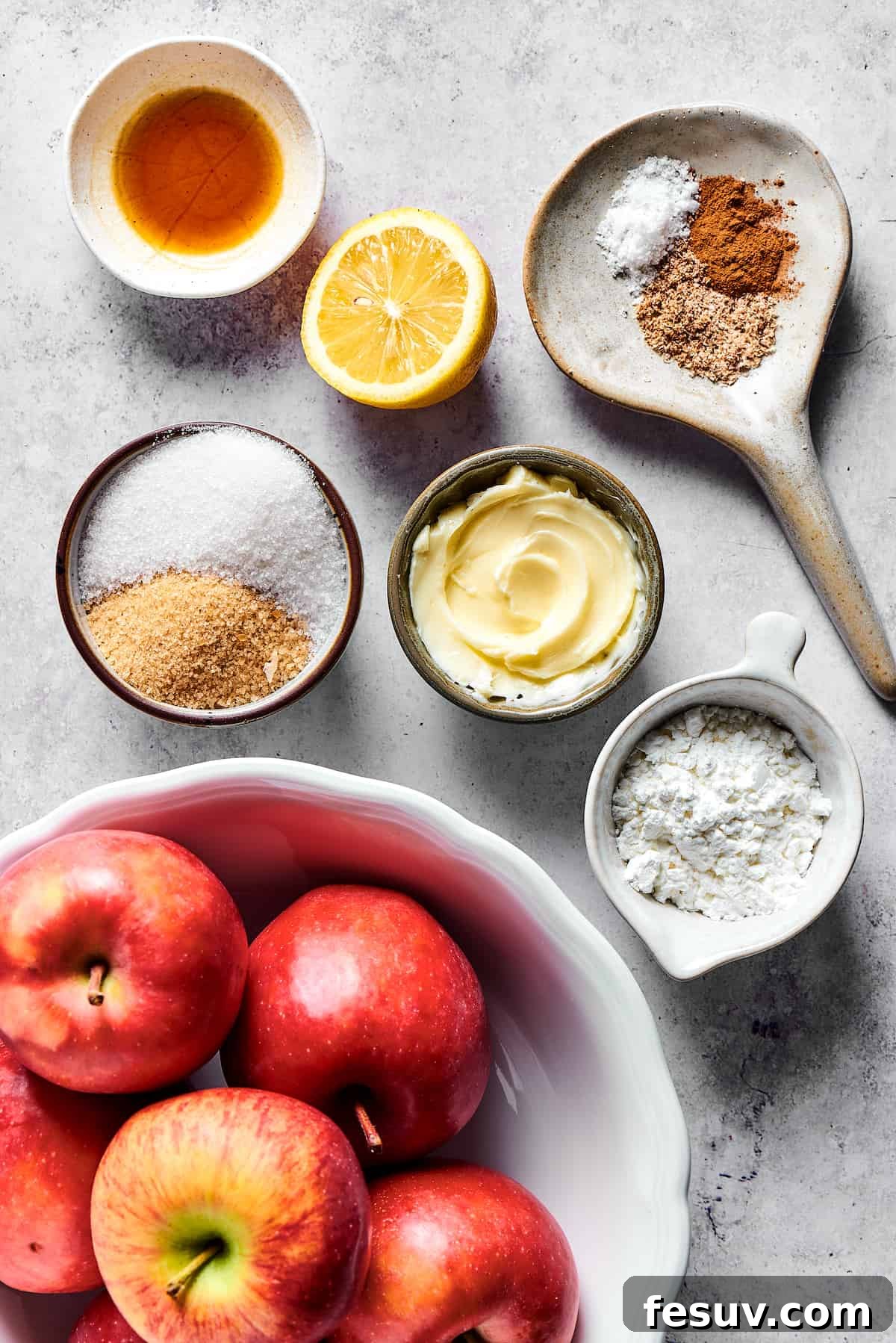 This old-fashioned Dutch Baby Pancake made in a cast-iron skillet is an easy, popover-like breakfast with homemade apple pie filling. Yum! Apple filling ingredients measured into small dishes and arranged on a work surface.