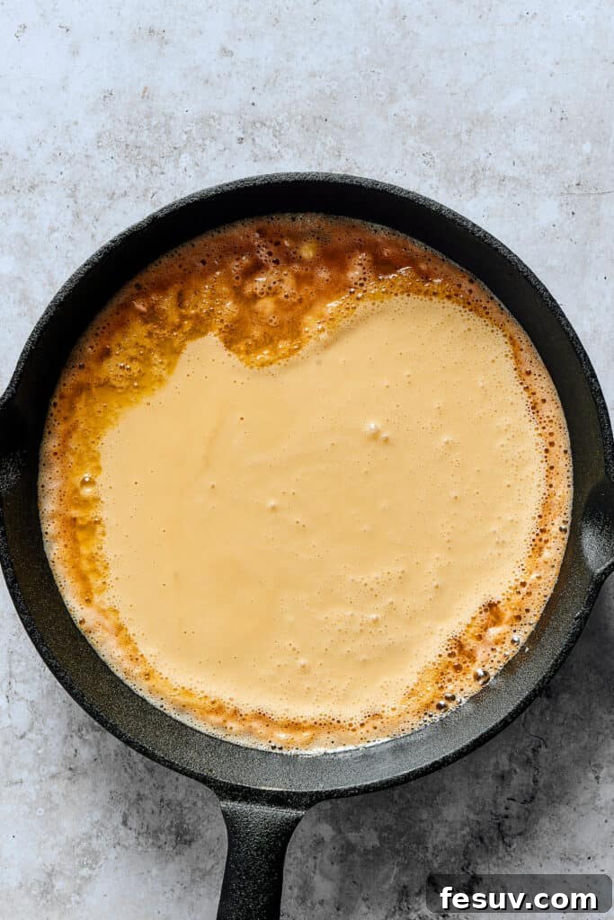 Skillet Cloud Pancake 4 Batter poured into a buttery skillet.