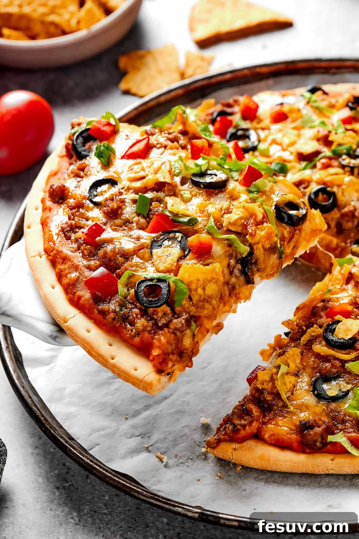 Lifting a slice of Southwestern pizza with a pie server, showcasing melted cheese and fresh toppings.