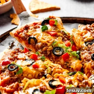 Lifting a slice of taco pizza with a pie server, ready to be served.