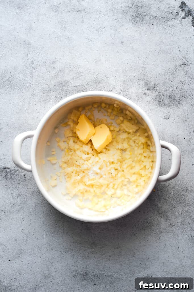 Ultimate Cheesy Bacon Potato Soup 6 Chopped onions and melting butter gently cooking in a large soup pot, releasing their aromatic flavors.